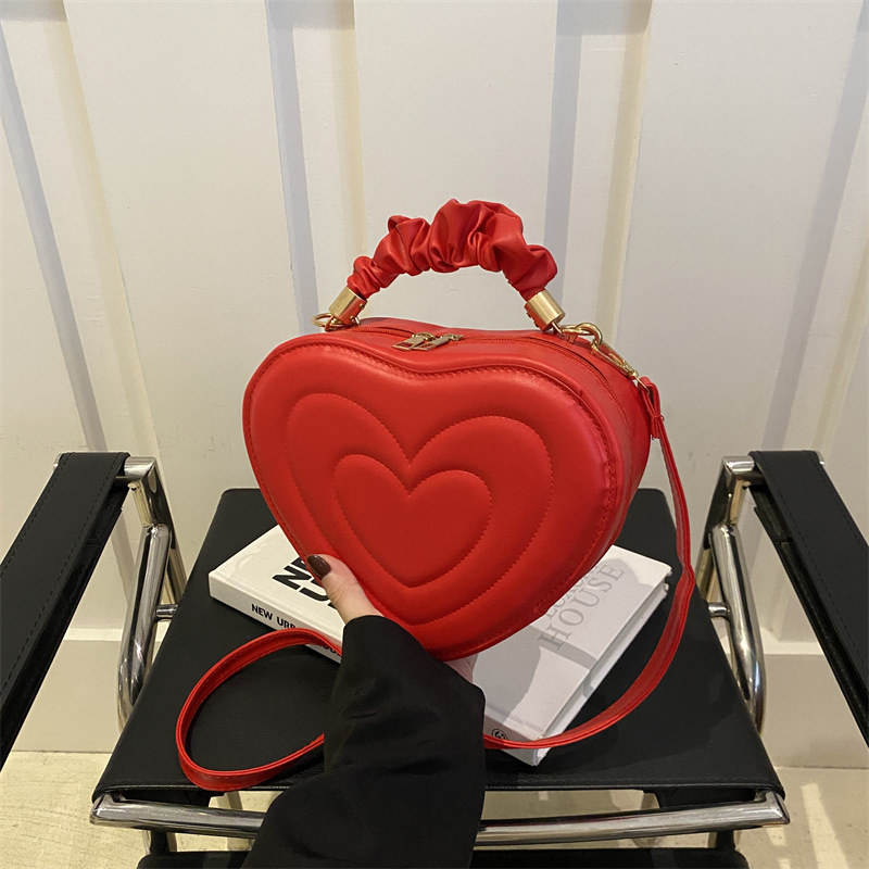 2024 otoño y invierno de mujeres nuevas caramelo de cáscara dura bolso de hombro de color corazón bolso de moda bolso de amor amor amor impresión