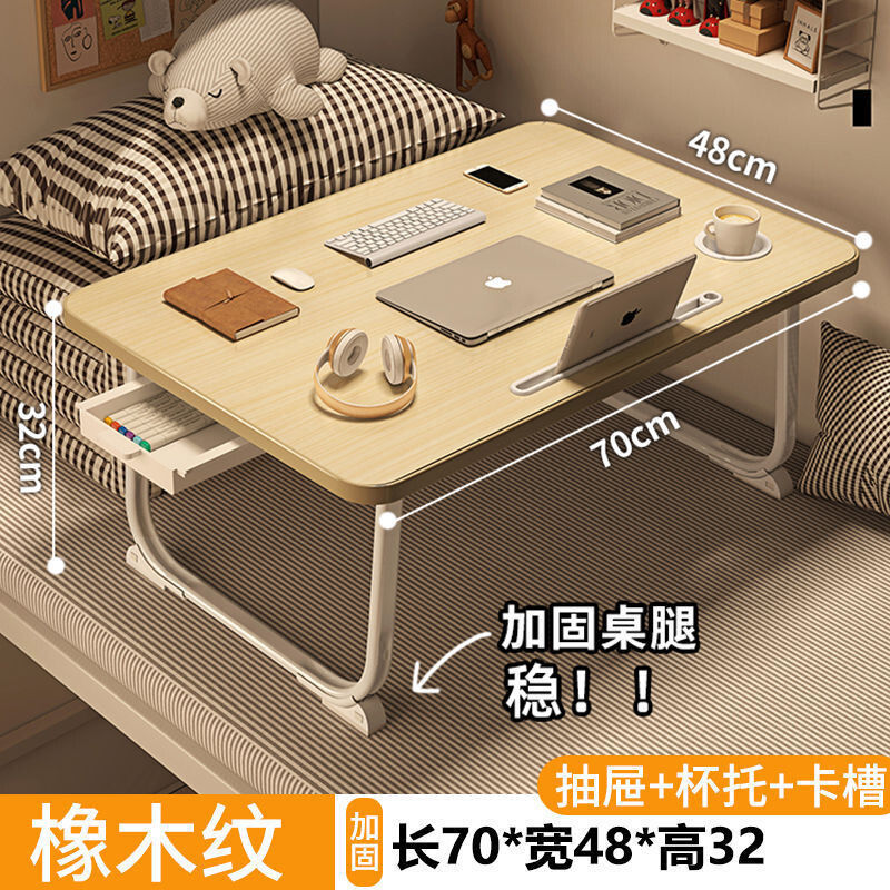 ベッドの上の小さい机のノートパソコンの机の上で折り畳みます。|undefined
