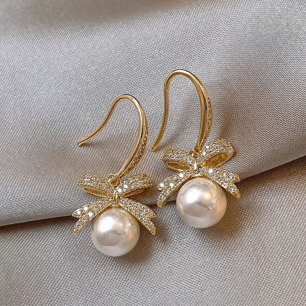 Golden earrings with bow from pearl