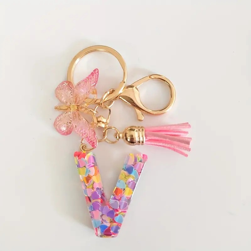 2024 transfronteriza en stock resina rosa con lentejuelas 26 letras inglesas llavero colgante mariposa borla Accesorios