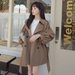 カレー色の短いウインドブレーカーのコートの女性はゆったりしています。