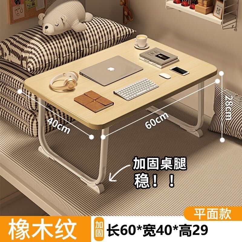 ベッドの上の小さい机のノートパソコンの机の上で折り畳みます。|undefined
