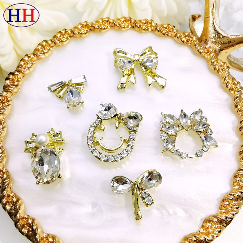 Nuevos accesorios de uñas de aleación especial de comercio electrónico transfronterizo lote mixto sonrisa cara arco uñas pegadas fábrica de diamantes al por mayor