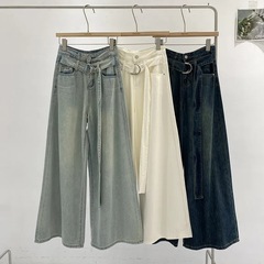 レトロでシンプルでゆったりとした水洗いデニムの広い足でズボンを引きずっています。