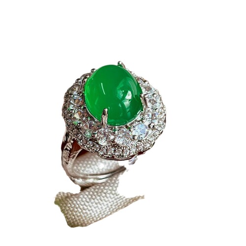 A natural light green jadeite egg face ring with a large, eye-catching green emerald, resembling jadeite, for women.