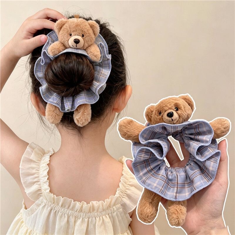 Oh my gosh, it's super cute and adorable! This plush bear plaid scrunchie is a playful accessory for creating a bun hairstyle Oh my gosh, it's super cute and adorable! This plush bear plaid scrunchie is a playful accessory for creating a bun hairstyle