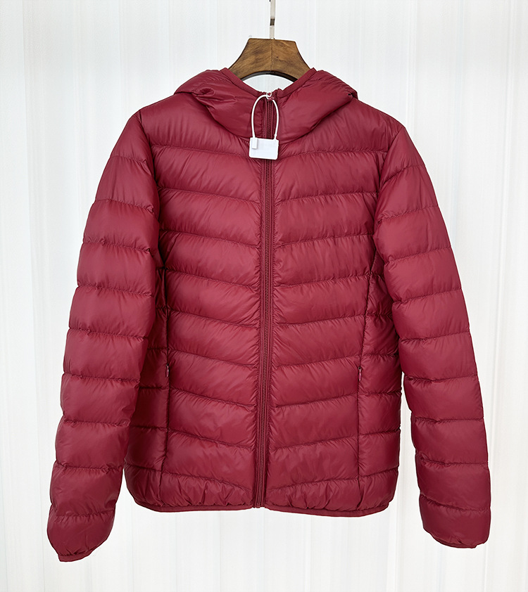 Chaqueta de plumón ligera para mujeres otoño y invierno 2025 nueva chaqueta de plumón de costillas con capuchón corto conveniente para almacenar chaqueta pequeña
