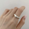 Small design ring, silver 925 sample, on index finger, trend of season