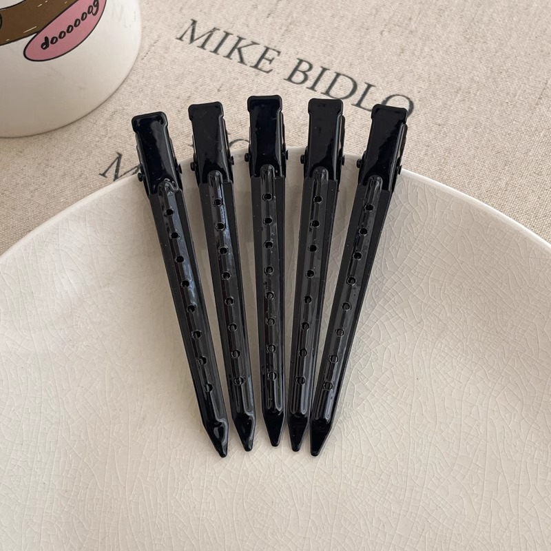 Clip de cabello sin marca especial para lavar la cara y maquillaje con clip de boca de pato posicionado en la parte lateral de la frente frente