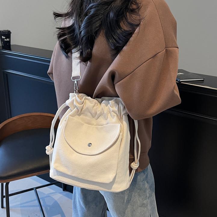 Bolsa de cubo de lona de moda de comercio exterior para mujeres 2025 nuevo estilo versátil bolso de hombro simple ocio nicho plegado mochila