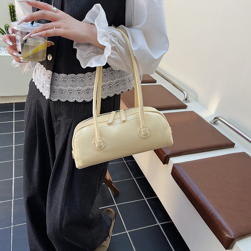 High-end nicho de moda bolso de hombro de mano para mujeres 2025 verano nuevo estilo simple bolso de viaje de palo bolso debajo de la axila
