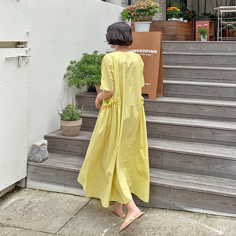 夏の服の新型韓国版はゆったりしていて、やせている半袖の黄色の大きいサイズのワンピースの女性のカジュアルな気質のA字の大きい振り子の長いスカートが見えます。