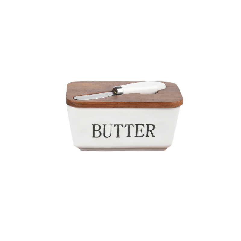 Mantequillera de cerámica con tapa de madera y cuchillo, apta para uso alimentario.