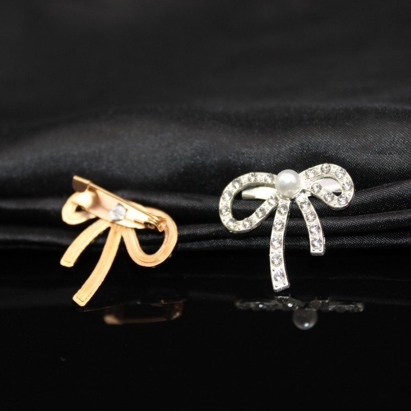 Metal brooch from pearl with bow