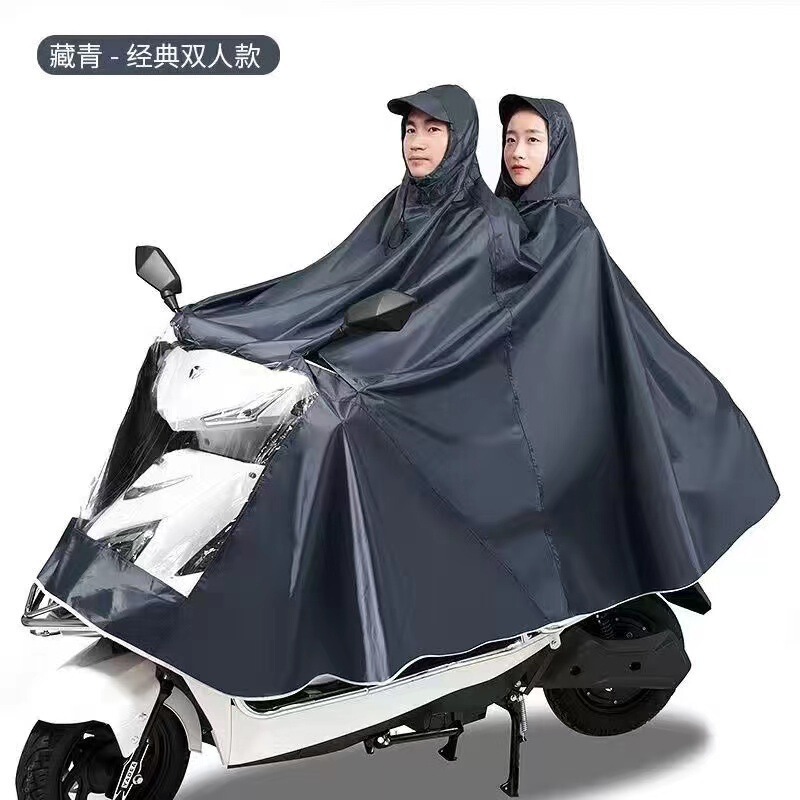 レインコート電気自動車のレインコートを大きくして、オートバイの二人のシングル男性女性が豪雨防止全身に足を隠します。|undefined