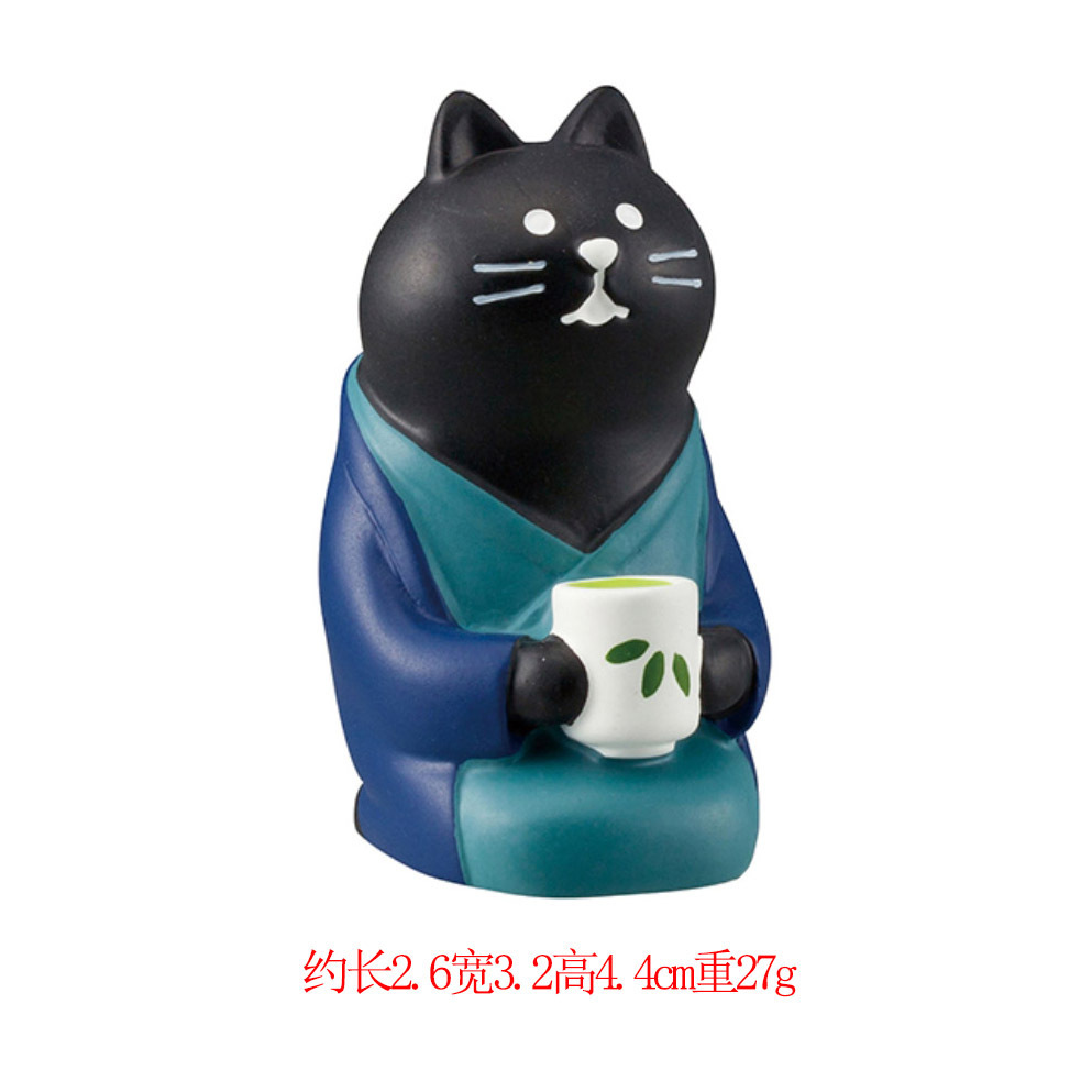 무릎을 꿇고 차를 마시는 검은 고양이