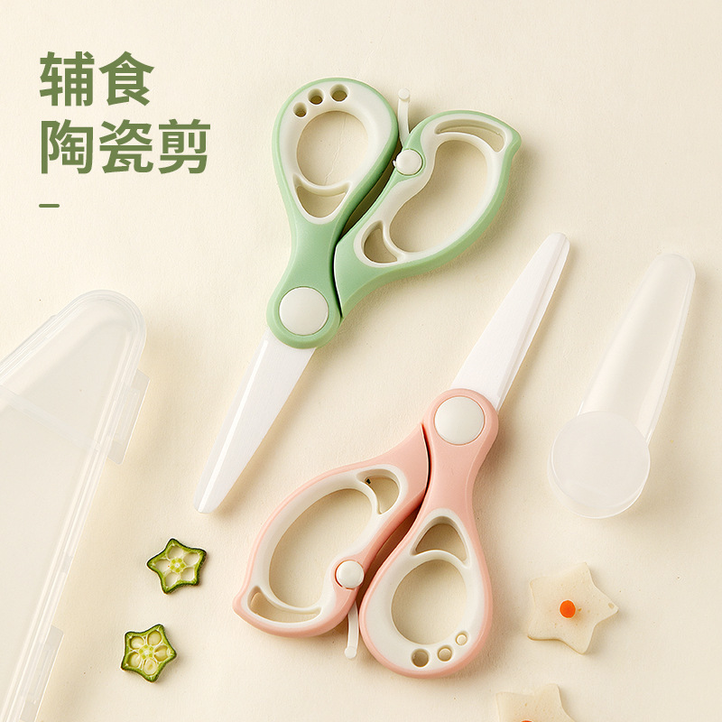 陶磁器のサプリメントは赤ちゃんの食べ物を切ります。はさみは携帯で肉を切ります。