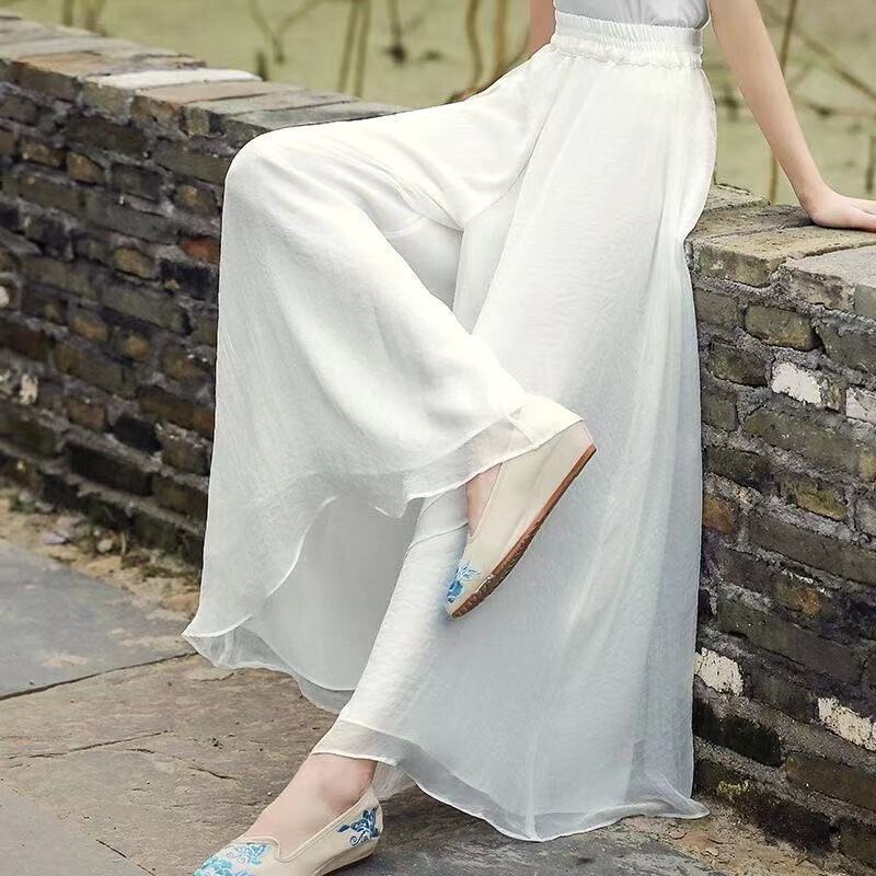 White chiffon long regular-style wide-leg pants, casual skirt-pants with a flowing drape and large hem White chiffon long regular-style wide-leg pants, casual skirt-pants with a flowing drape and large hem