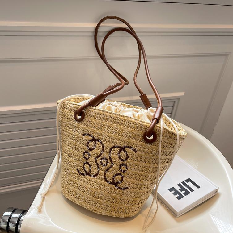 Bolsos tejidos populares de verano para damas 2025 nuevo bolso de cubo de moda de nicho de venta caliente bolso de hombro de estilo occidental de todo fósforo