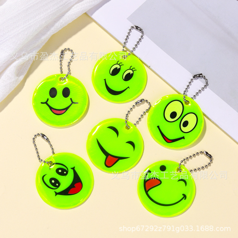 Muchos colgantes reflectantes transfronterizos sonrientes para niños viajan por la noche PVC seguro al aire libre