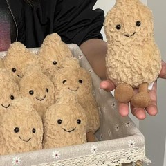 イギリスの趣味の落花生の美食のかわいいぬいぐるみは人形をなだめて子供のプレゼントに付き添います。