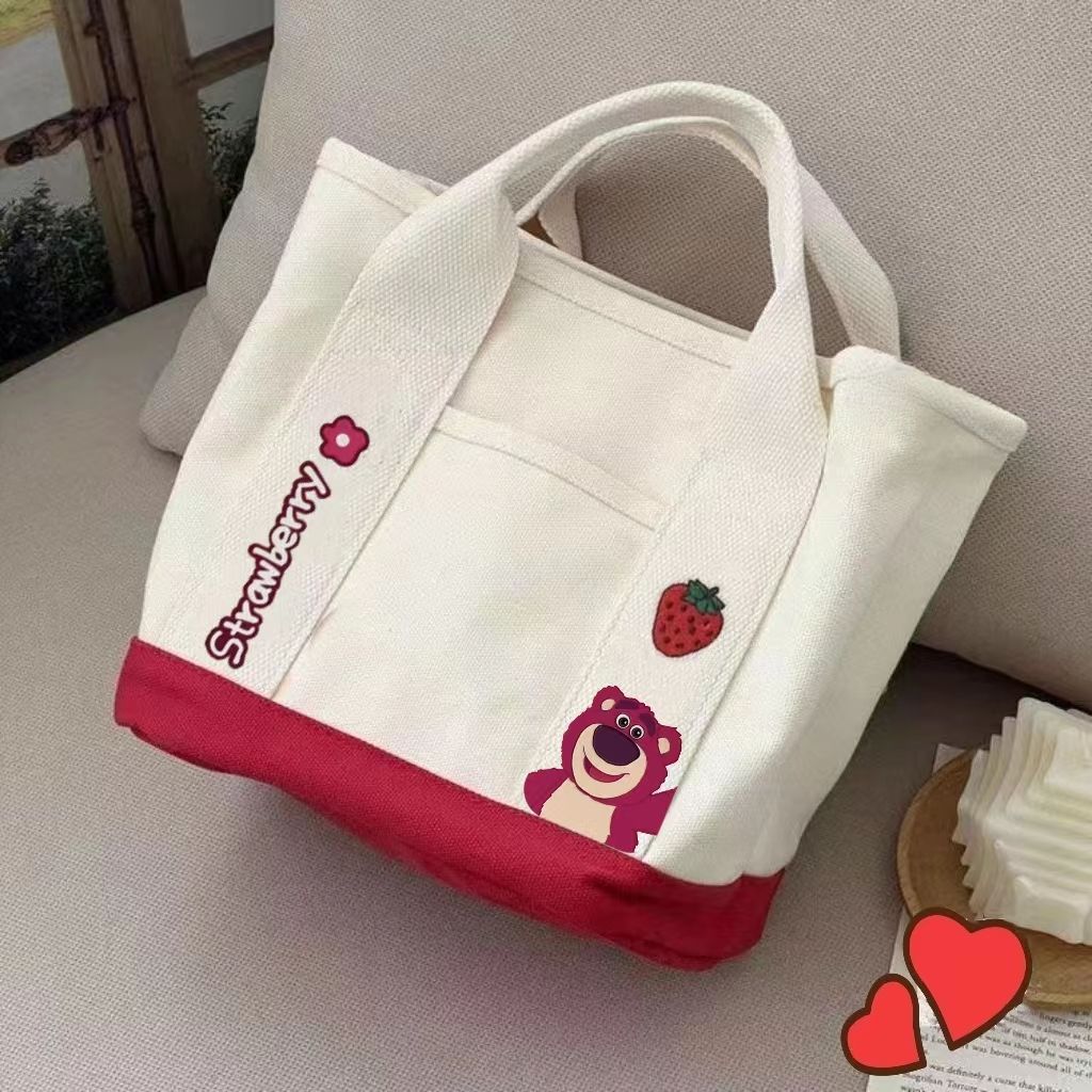 A small handbag is carried by a female student going out. She is carrying a 2024 new style bag, a mini canvas bag, and a Korean version bento bag for female students Application Scenario