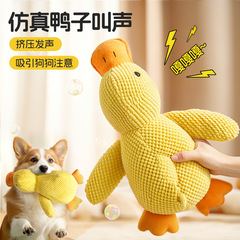 犬のおもちゃは小さい黄色のアヒルの中で小さいぬいぐるみと一緒に寝ます。