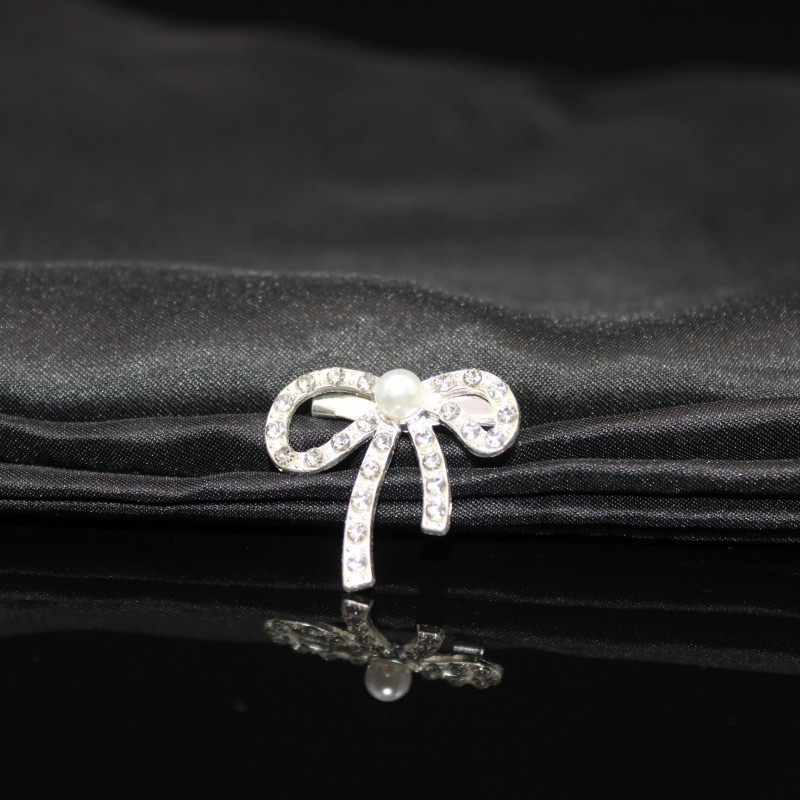 Metal brooch from pearl with bow