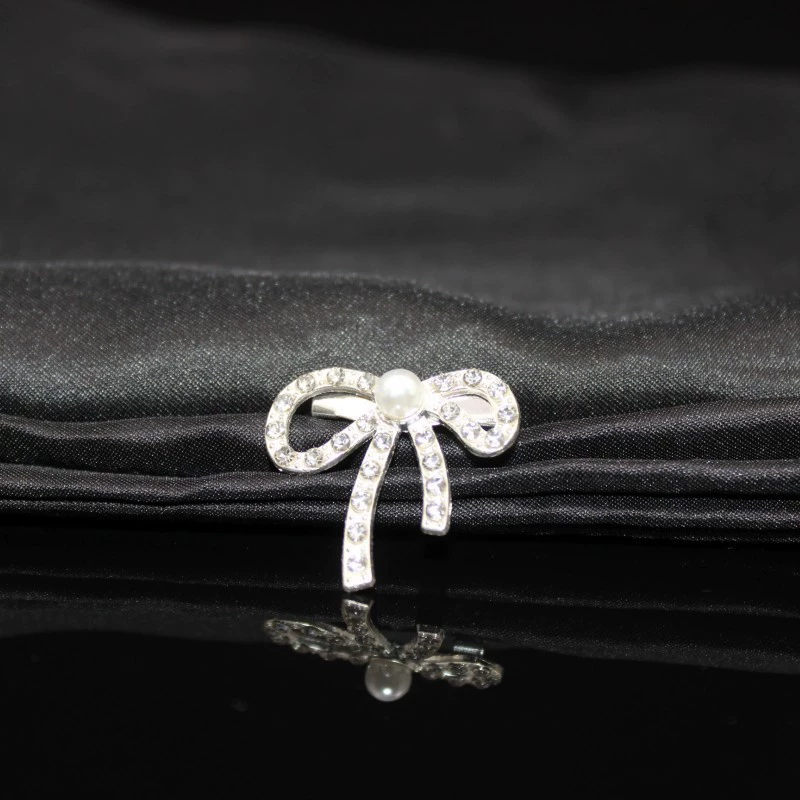 Metal brooch from pearl with bow