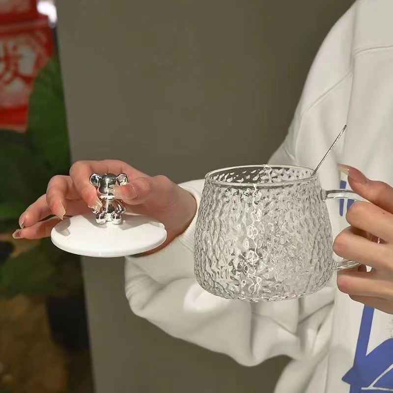 かわいい熊のガラスのコップの女子学生のマグカップは蓋のスプーンの氷河の杯のハンマーの紋様の牛乳の杯を持ってスプーンの取っ手を持ちます。|undefined