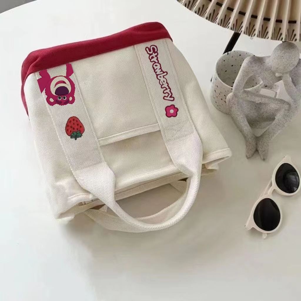 A small handbag is carried by a female student going out. She is carrying a 2024 new style bag, a mini canvas bag, and a Korean version bento bag for female students Item Picture