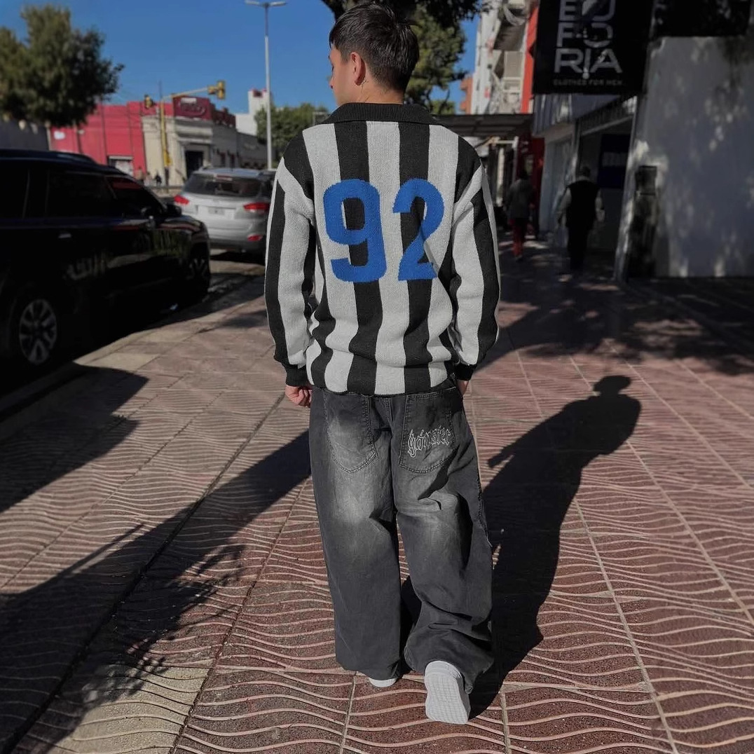 Suéter de punto estilo jersey retro americano con rayas verticales para hombre y mujer, con estampado de letras y cuello tipo polo, Otoño/Invierno 2025.