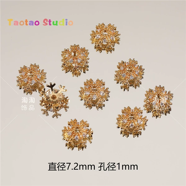 A small gold (copper inlaid with zirconium) snowflake holder