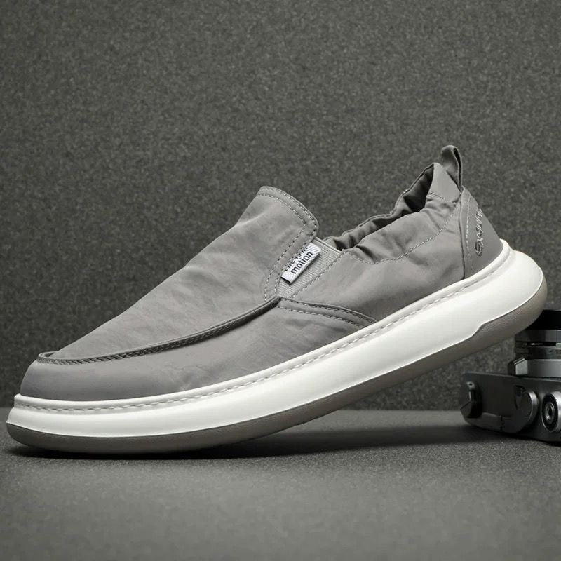 Zapatos casuales de lona de alta gama para hombre, verano 2026, sencillos y versátiles, de caña baja, sin cordones, ligeros, delgados y transpirables.
