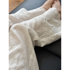 怠惰な風の白い透かし彫りの刺繍の亜麻の広い足のズボンの女性の2025新型のデザイン感の組み合わせはやせている綿麻のズボンを現します。