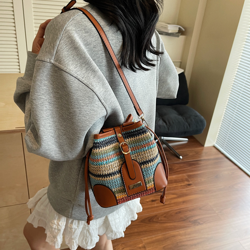 Bolso tejido femenino 2025 verano nuevo estilo juego junto al mar bolso de cubo de viaje tendencia bolsa de paja de mensajero de todo fósforo de nicho