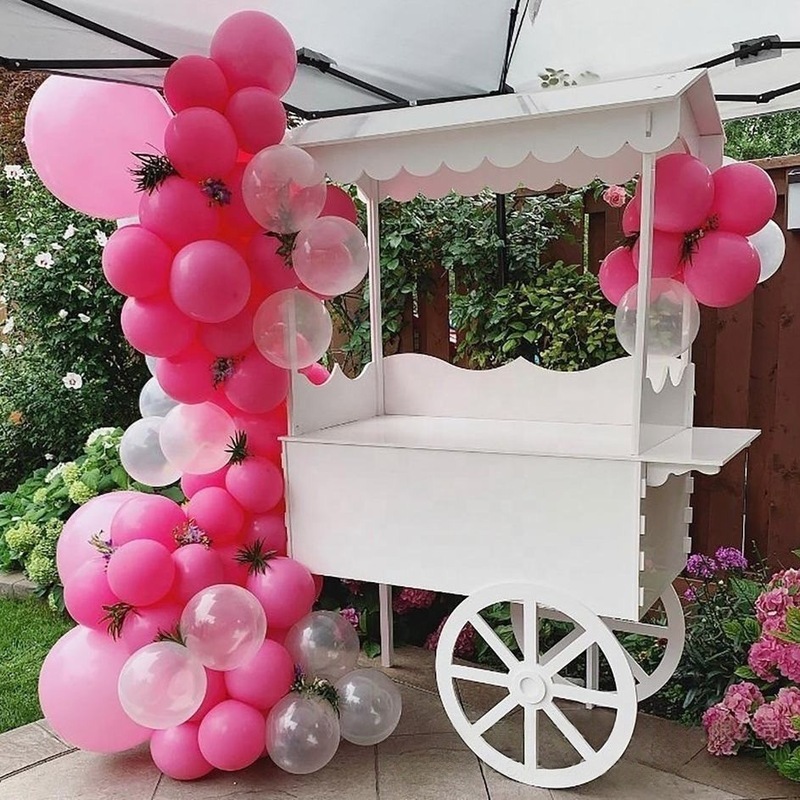 木製の車輪付き手押し車は甘い結婚式のキャンディー車の花車パーティーの市場に屋台のカートを並べます。|undefined