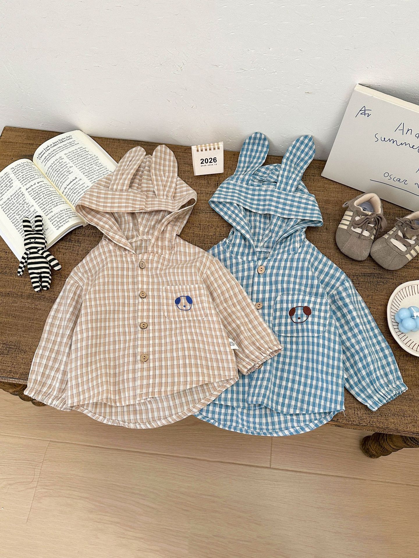 Camisas lindas coreanas para bebés de sexo masculino y femenino 2026 primavera nueva camisa con capuchón de estilo a cuadros para niños extranjeros