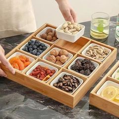 竹の木の乾燥した果物のナッツの箱の火鍋の店は格の食事の皿を分けて囲みます。