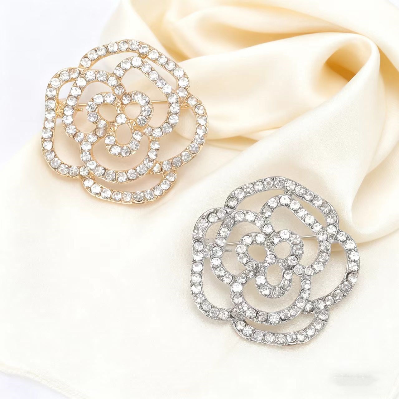 Elegant kameliabrosch med hålmönstrad rosdesign för rockar_voghion.com