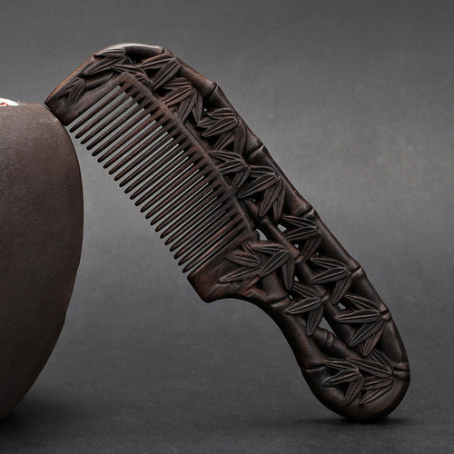 A solid wood hair comb with a black sandalwood handle, double-sided carved floral design, fine-toothed, ancient-style gift comb for smooth hair and massage.
