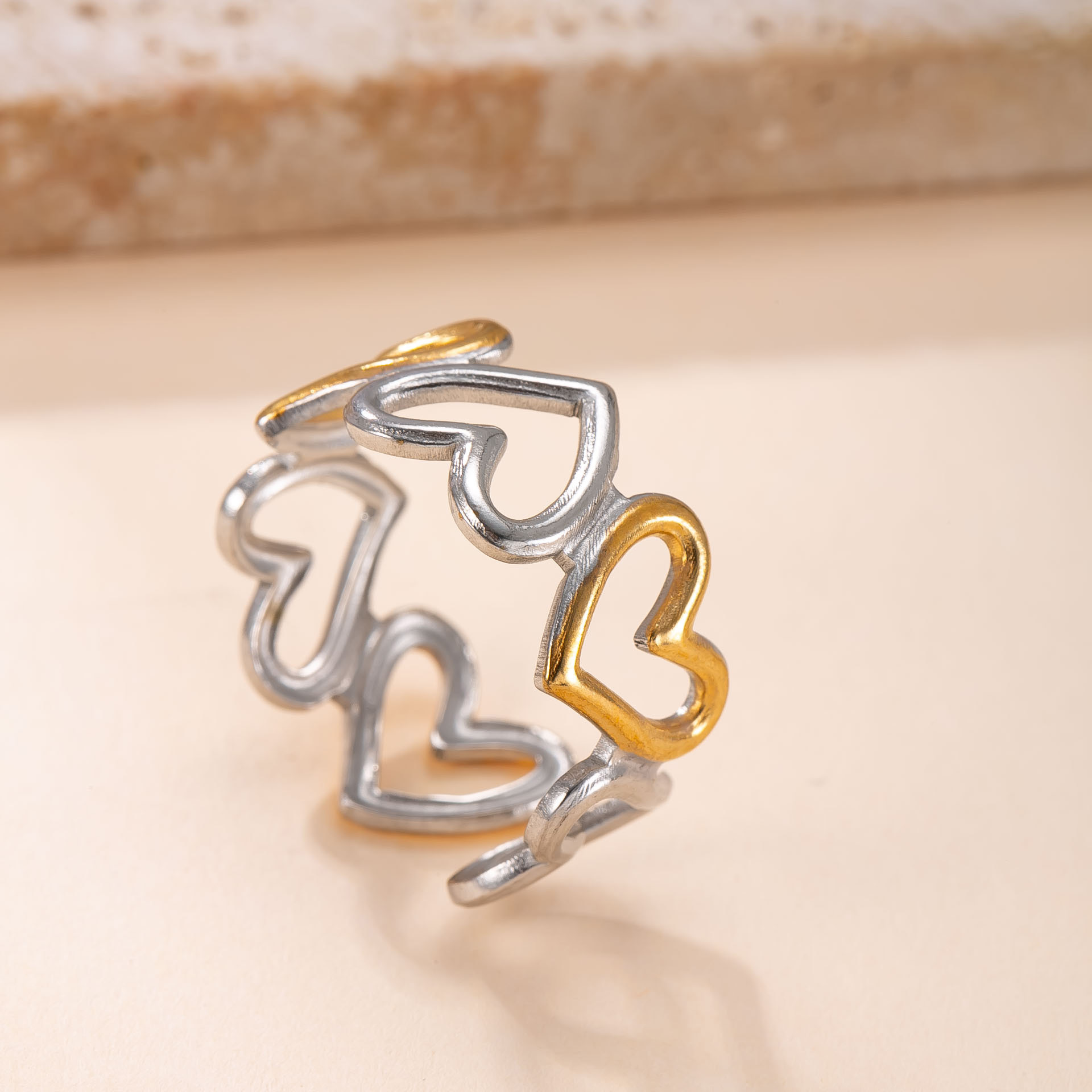 Venta caliente transfronteriza anillo de acero inoxidable diseño de nicho femenino anillo abierto a juego de colores aceite hueco amor fábrica de anillos de acero de titanio