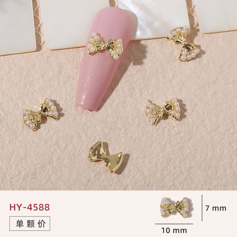 Uñas mariposa joyería nueva línea popular perla arco metal decoración de uñas pequeños accesorios de joyería al por mayor