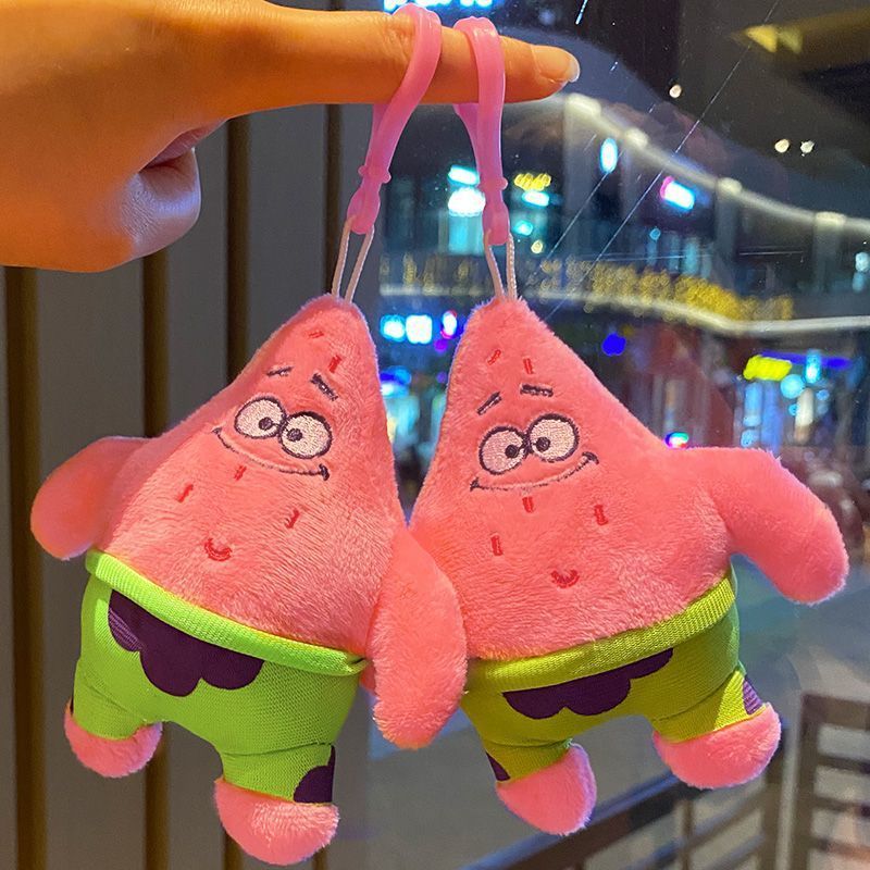 かわいいスポンジの赤ちゃんの大星の鍵はぬいぐるみのおもちゃのかばんのストラップを掛けて小さいペンダントを包みます。|undefined
