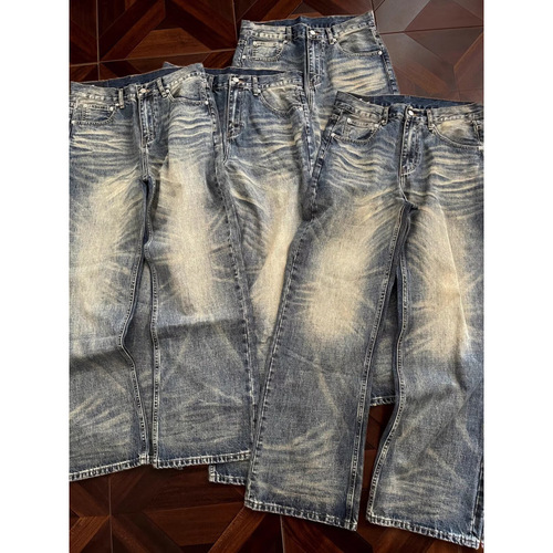 Vintage punk-style straight-leg, low-rise, slightly flared denim trousers with embroidery and a flowing, relaxed fit.