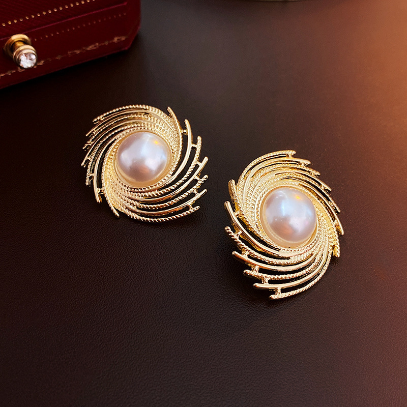 Silver needle surrounds pearl earrings