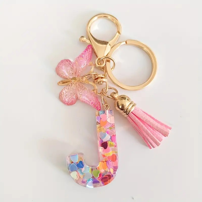 2024 transfronteriza en stock resina rosa con lentejuelas 26 letras inglesas llavero colgante mariposa borla Accesorios
