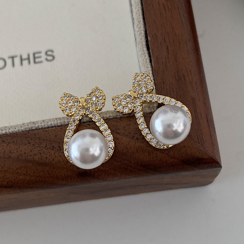 Bow tie pearl earrings with diamond inlay, exquisite small earrings, simple and high-end feeling earrings, light luxury, socialite gathering earrings, female