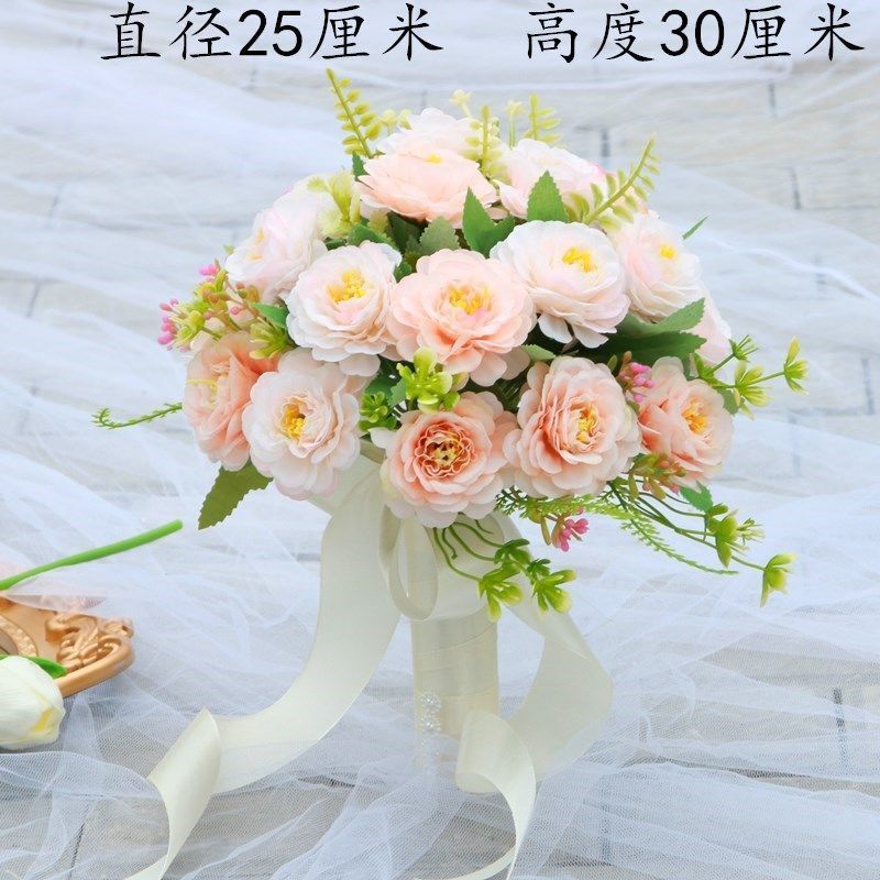 手に花を持つ新婦の韓国式結婚式の領収書のシミュレーションの花束の森系のウェディングドレスの撮影の道具の手に花をささげます。|undefined