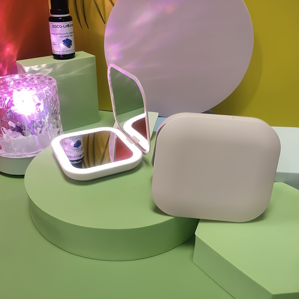 Venta directa de fábrica Espejo de maquillaje Regalo portátil Espejo de maquillaje de mano plegable con luz de carga Modelo avanzado transfronterizo